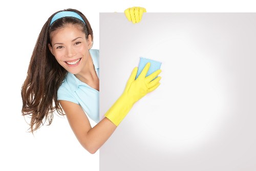 Professional carpet cleaner treating a hallway carpet in W2